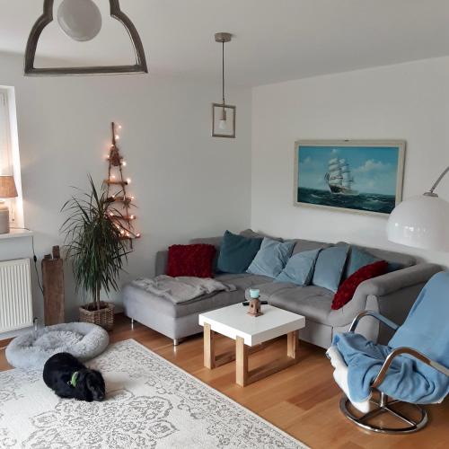 a living room with a couch and a dog laying on the floor at Ferienhaus Elisenhuus in Tönning