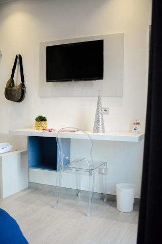 a desk with a chair and a tv on a wall at Nnakkara Guest House in Santo Stefano di Camastra