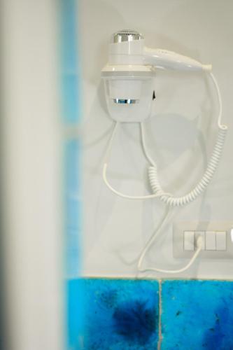 a close up of a white phone on a wall at Nnakkara Guest House in Santo Stefano di Camastra