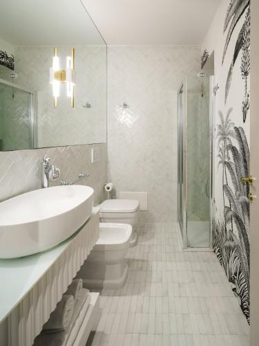 a bathroom with a sink and a toilet and a shower at Birkin Porto 1870 in Cagliari