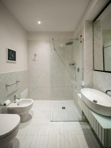 a bathroom with a toilet and a sink and a shower at Birkin Porto 1870 in Cagliari