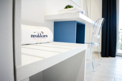 a white counter with a chair in a room at Nnakkara Guest House in Santo Stefano di Camastra
