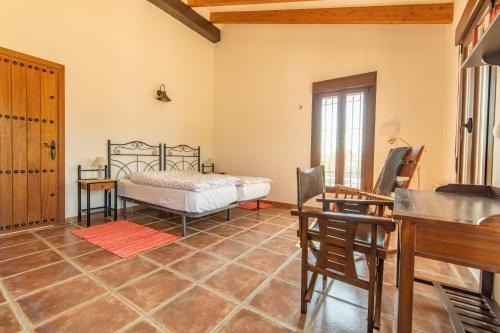 1 dormitorio con cama, mesa y escritorio en Cortijo Cantares, en Málaga