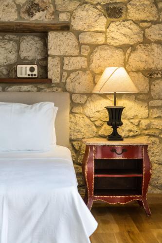 a bedroom with a bed and a table with a lamp at LuCe Design Hotel - Special Category in Alacati