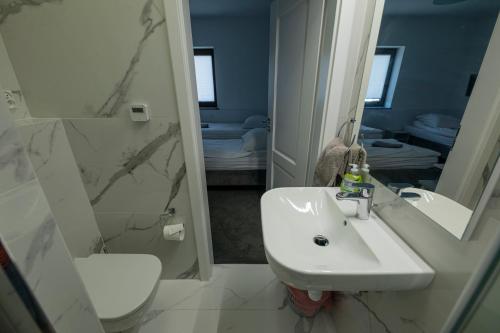 a bathroom with a sink and a toilet and a mirror at Bon Ton in Szczecin
