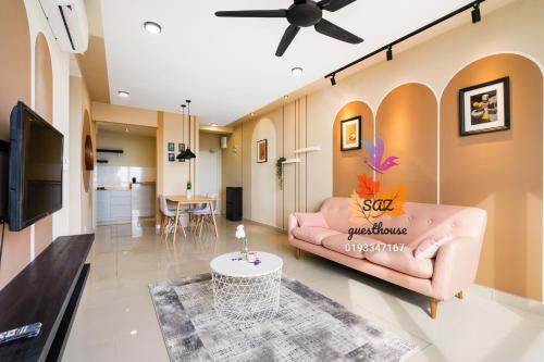 uma sala de estar com um sofá rosa e uma mesa em SAZ Guesthouse em Semenyih