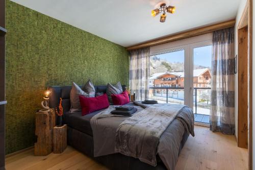 een slaapkamer met een groot bed en een groot raam bij Buccara Panoramasuite Brixental - Brixen im Thale in Brixen im Thale