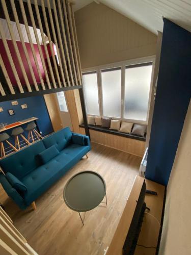 - un salon avec un canapé bleu et une table dans l'établissement les Hallettes du havre hyper centre 300 de la mer, au Havre