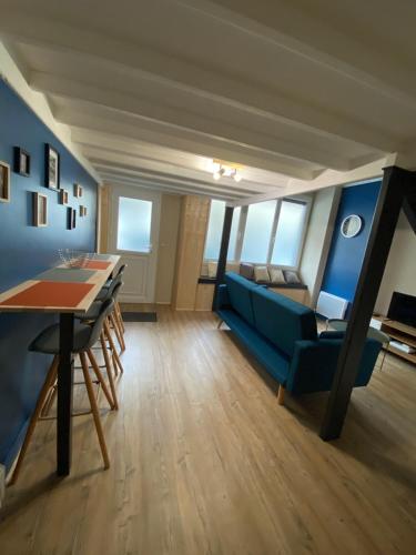 un salon avec un canapé bleu et une table dans l'établissement les Hallettes du havre hyper centre 300 de la mer, au Havre