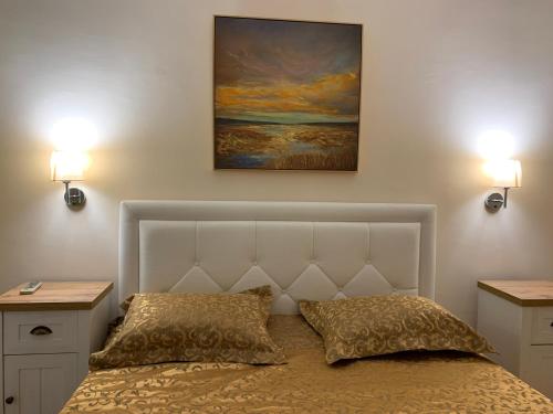 a bedroom with a bed with two lamps and a painting at Elite Apartments in Sunny Beach