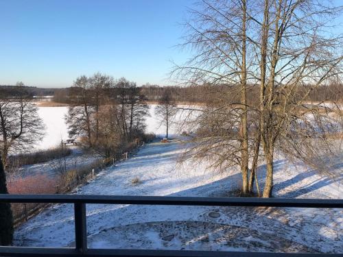 a view of a snow covered field from a balcony at Domwigierski pl -Jeziorki -GR- Comfort-Ferienhaus-Polen - własna linia brzegowa i sauna in Wysoki Most