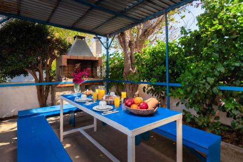 un tavolo blu con un cesto di frutta sopra di Litsas Studios a Fánai