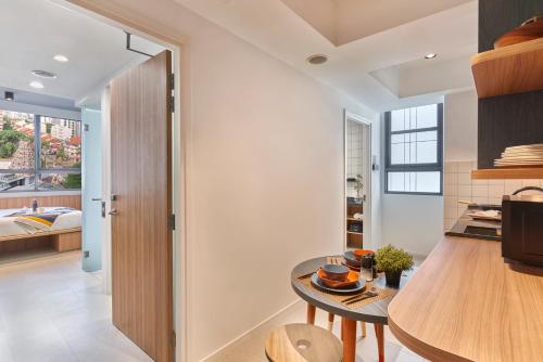 a kitchen with a table and a room with a bed at lyf Farrer Park Singapore in Singapore