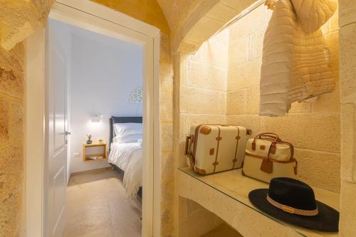 ein Zimmer mit Koffer und Hut auf der Theke in der Unterkunft Peninsula Apartments-Appartamento Pietrabianca in Carmiano