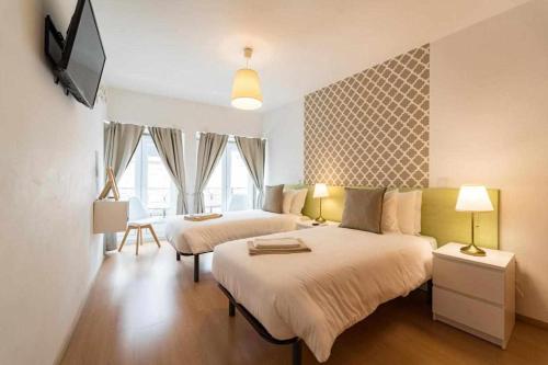 Sé Guesthouse في براغا: غرفة نوم بسريرين وتلفزيون بشاشة مسطحة