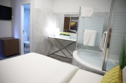 a bathroom with a tub and a sink and a toilet at Miami Beach Hotel Tel Aviv in Tel Aviv
