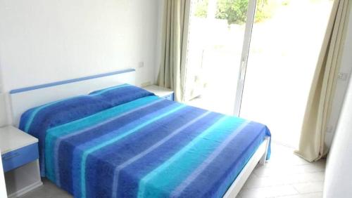 a bedroom with a bed with a blue blanket on it at Casa Silvia Climatizzata, giardino privato e posto auto privato cod IUN S9185 in Viddalba