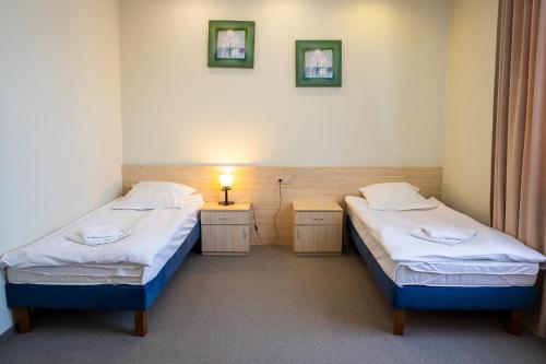 a room with two beds and a lamp in it at Hotel Kardamon in Tarnów