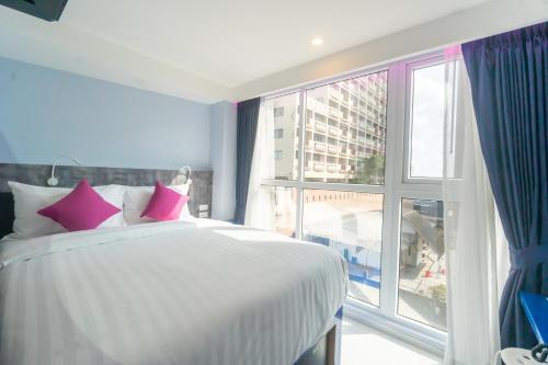 a bedroom with a bed and a large window at Spark Hotel - MRT Queen Sirikit - SHA Extra Plus Certified in Bangkok