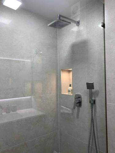 a bathroom with a glass shower with a sink at Апартаменти в центрі Тернополя in Ternopilʼ