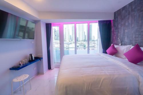 a bedroom with a large bed with pink pillows at Spark Hotel - MRT Queen Sirikit - SHA Extra Plus Certified in Bangkok