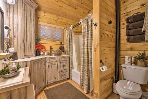 a log cabin bathroom with a toilet and a shower at Cozy Noras Hideaway - Charming, Quiet Log Cabin in Duck Creek Village
