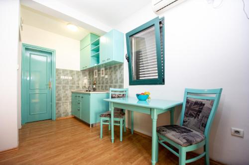 a kitchen with a blue table and two chairs at Vila Il Pescatore in Petrovac na Moru