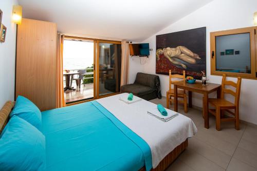 a bedroom with a blue bed and a table and a chair at Vila Il Pescatore in Petrovac na Moru