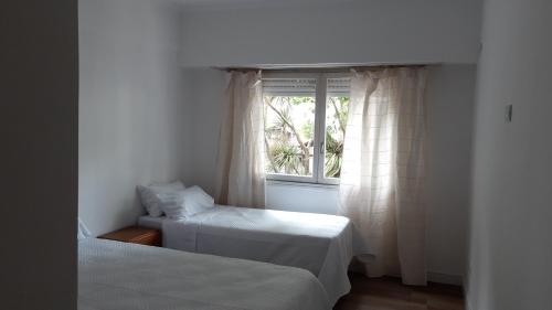 1 dormitorio con 2 camas y ventana en Cala Hotel en Mar del Plata