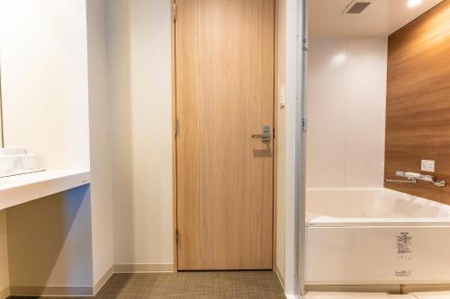 a bathroom with a tub and a sink at CVS Bay Hotel in Urayasu