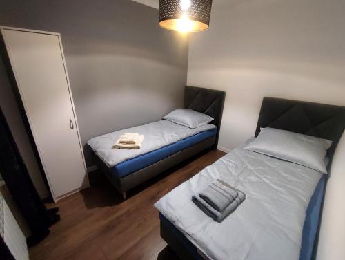 um pequeno quarto com duas camas e um candeeiro em Apartament Krzemyk em Sandomierz