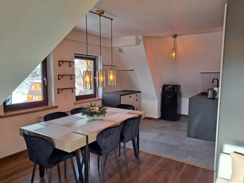 een keuken en eetkamer met een tafel en stoelen bij Apartament Stanisława in Zakopane