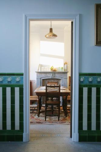 a dining room with a table and a table and chairs at B&B Herenhuis1919 in Lo-Reninge