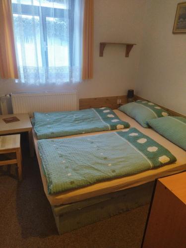 A bed or beds in a room at Penzion Borovice