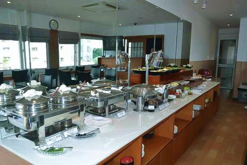 una línea de buffet con muchos platos de comida. en Hoàng Gia Hotel Nhân Hòa, en Hanói