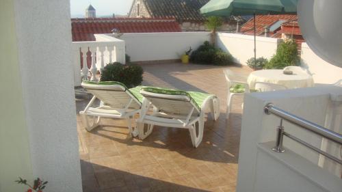 eine Terrasse mit einem Tisch, Stühlen und einem Sonnenschirm in der Unterkunft Apartments Vodice Marica in Vodice