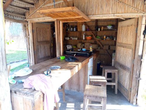 una cucina con tavolo in una casa di legno di Povoado Bitonga a Inhambane