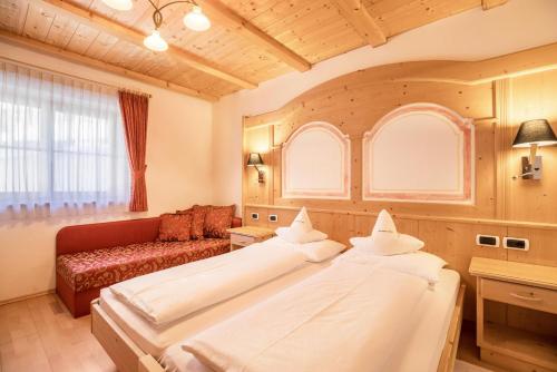 una grande camera con due letti e un divano di App Lisüra Cir a Corvara in Badia