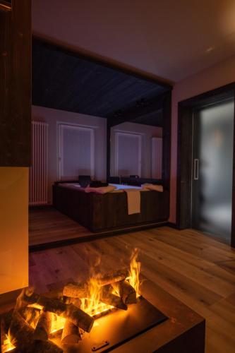a room with a bed and a fire in the floor at Teverone Suites & Wellness in Lamosano