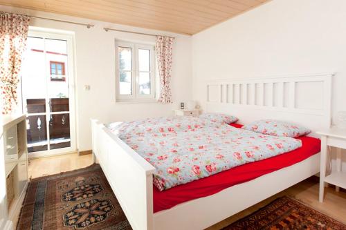 a white bedroom with a large bed and a window at Beim Schlenz in Reit im Winkl