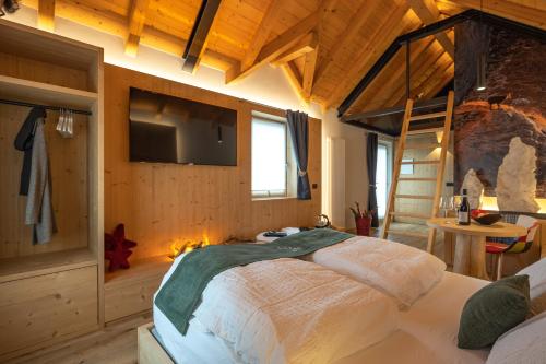 a bedroom with a bed with a tv and a fireplace at Teverone Suites & Wellness in Lamosano
