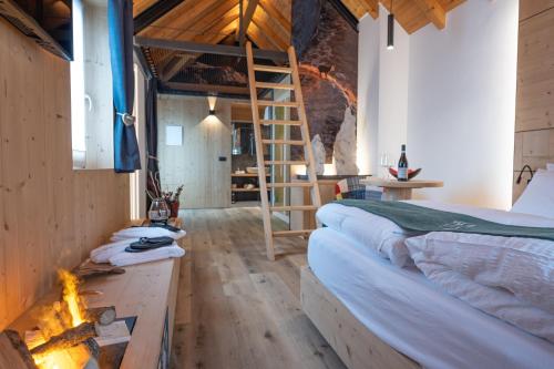a bedroom with two beds and a ladder and a fireplace at Teverone Suites & Wellness in Lamosano