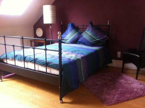 Schlafzimmer mit einem Bett mit blauer Bettwäsche und einem Teppich in der Unterkunft Das Gästehaus in Offenburg