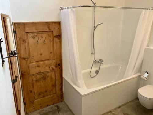 a bathroom with a tub and a shower and a toilet at Stalla d' Immez in Santa Maria Val Müstair