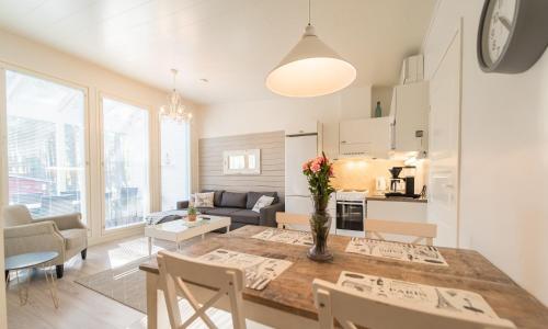 una cucina e un soggiorno con tavolo e sedie di Jäkälätie Apartments by Hiekka Booking a Kalajoki