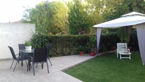 a patio with a table and chairs and an umbrella at Διαμέρισμα με κήπο in Orestiada