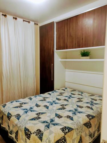 a bedroom with a bed with a quilt on it at Apto 2 quartos em Arroio do Silva in Arroio do Silva