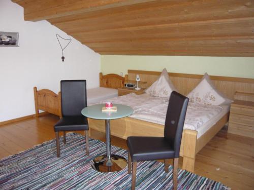 1 dormitorio con 1 cama, mesa y sillas en Ferienwohnung Eder, en Mauth