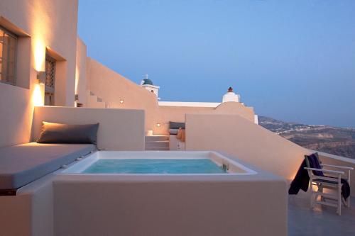 a hot tub on the balcony of a house at Ikia Kriton in Imerovigli