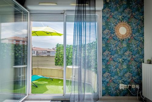 d'une porte coulissante en verre avec vue sur la terrasse. dans l'établissement Le Jardin des Consuls - T3 - Parking - Balcon orienté sud, à Montpellier